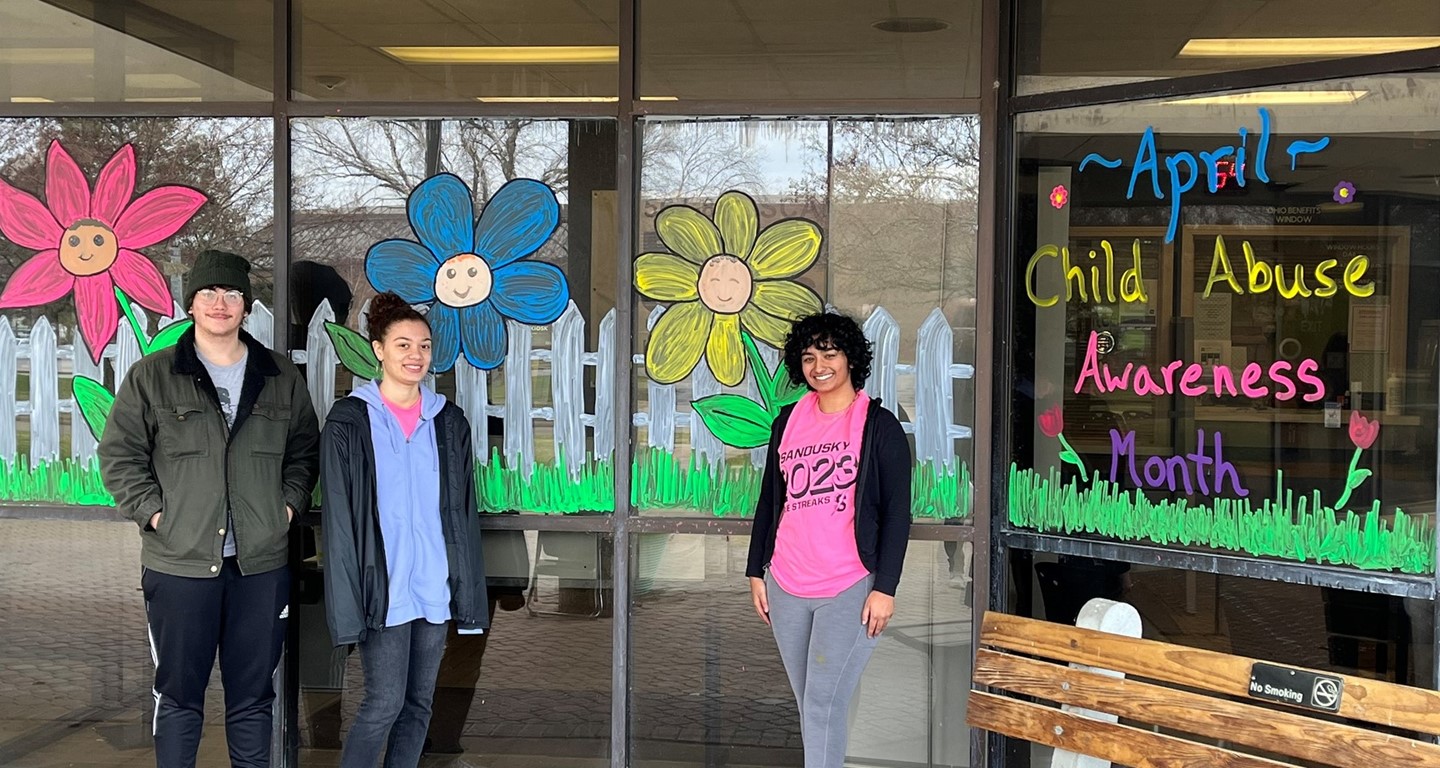 Anisha Chopra, Aydin Orman and Alena Spears volunteered their time to help bring awareness to child abuse by painting the windows of Erie County Job & Family Services for Child Abuse Awareness Month. 